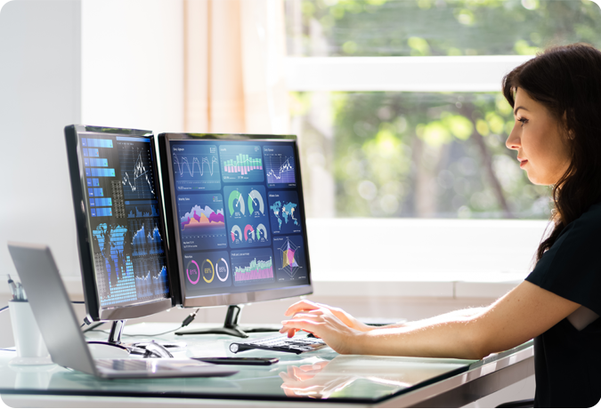 woman looking at monitor with reports displayed